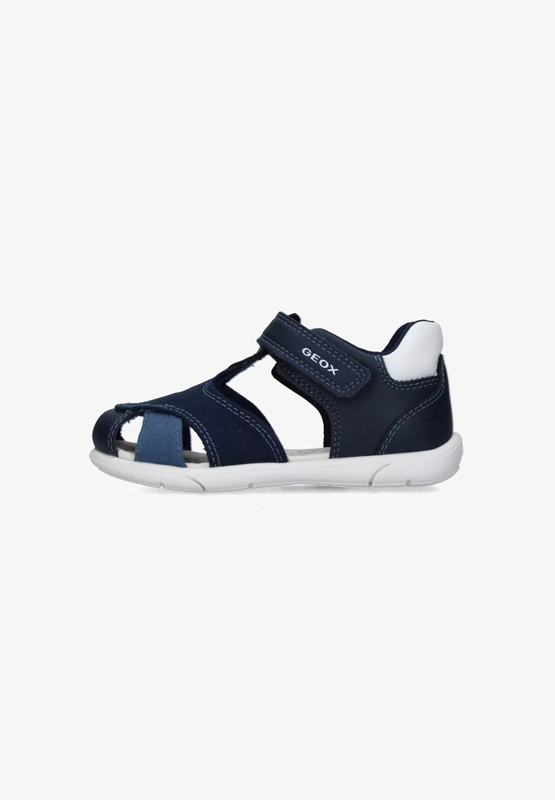Sandale bleu marine en cuir et mesh, dotée d'un design ouvert à l'avant, d'une sangle Velcro et d'une semelle en caoutchouc blanche pour une meilleure adhérence.