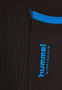 Zwarte atletische stof met fijne ribbels en een gladde textuur. Heeft blauwe accenten en een geprinte "hummel SPORTSWEAR" logo aan één kant.