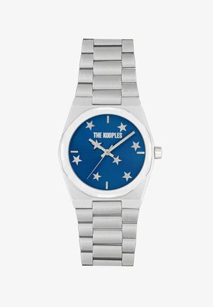 Orologio in metallo argento con quadrante blu e indicatori a forma di stella, contrassegnato con "THE KOOPLES". Design della bracciale in acciaio inossidabile liscia.