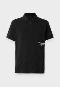 Crna polo majica od pamuka, s otvorom za tri gumba i malim bijelim logotipom s tekstom na lijevoj strani. Kratki rukavi.
