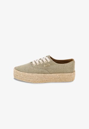 Zapatilla de lona en verde claro, con suela de yute y espuma, puntera redondeada y cordones de algodón beige. Acentuada con un logo de la marca.