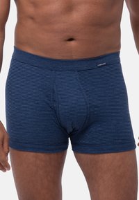 Tummansininen boxerimalli, jossa on teksturoidusta raidallisesta kuviosta valmistettu muotoilu, joustava vyötärönauha ja etupussin malli. Pehmeä kangas, joka on mukautuva muotoilultaan.