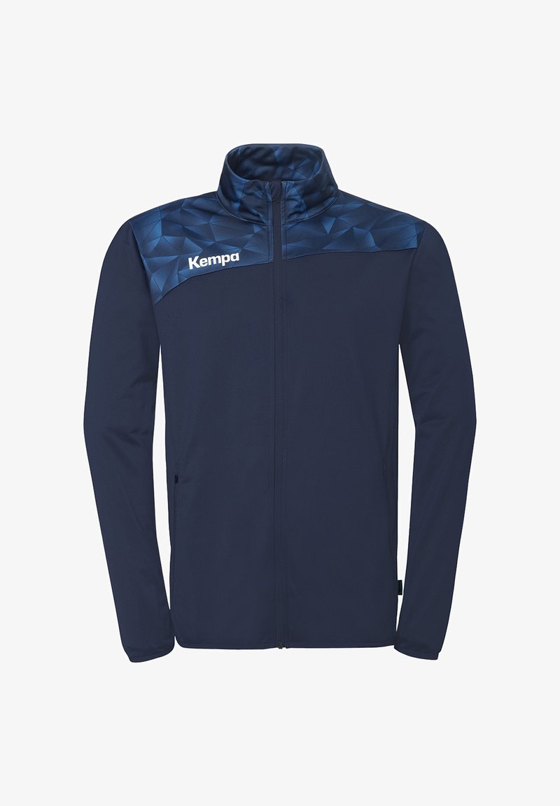 Veste de sport bleu marine zippée avec un motif géométrique sur les épaules et le logo "Kempa" sur le côté gauche de la poitrine.