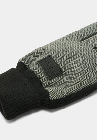 Rękawiczki z dzianiny w czarno-szarym wzorze jodełki; posiadają teksturowany czarny mankiet i małą prostokątną naszywkę z logo marki.