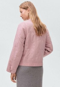 Giacca trapuntata rosa con finitura effetto texture, con maniche lunghe e lunghezza corta, vista da dietro.