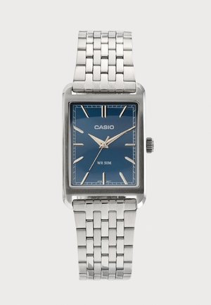 Ceas de mână Casio din metal argintiu, cu față dreptunghiulară albastră, marcaje orare argintii și brățară metalică legată, afișând ora 9:10:36.