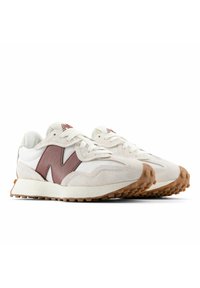 Pair of white and beige New Balance sneakers with brown "N" logos and rubber-studded soles, angled right on white background.
