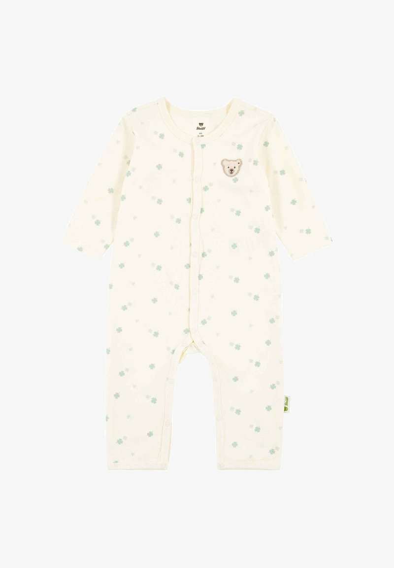 Kremowy kombinezon dziecięcy z długimi rękawami, wzorem zielonych koniczynek, przednimi zatrzaskami i małą naszywką z twarzą misia na piersi.