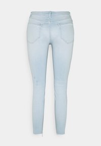 Ljusblåa skinny jeans med en mjuk denimstruktur, femficksdesign och slitna nederkanter vid anklarna.