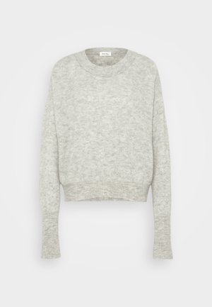 Svetlo siva skrajšana majica iz mehke pletenine. Ima okroglo ovratnico in dolge rokave z rebrastimi robovi. Diskretna tekstura po celotni površini.