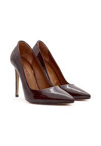 Zapatos de tacón alto de charol burdeos oscuro con punta afilada, interior texturizado y tacones delgados estilo stiletto. Diseño minimalista.