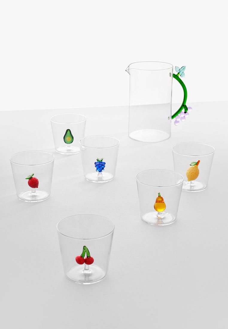 Przezroczysty plastikowy dzbanek z zielonym uchwytem i akcentami w kształcie motyli, obok sześciu przezroczystych kubków, z których każdy ma inny motyw owocowy.