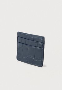 Porte-cartes en cuir bleu marine avec texture en croco embossée, comprenant trois fentes pour cartes et des bords cousus pour plus de durabilité.