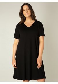 Zwarte jurk met korte mouwen, gemaakt van gladde stof, met een V-hals en een ontspannen pasvorm, die boven de knie valt. Heeft een eenvoudig, minimalistisch ontwerp.