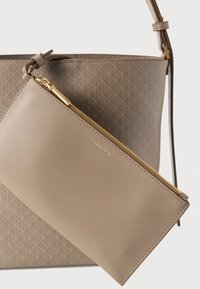 Μπεζ τσάντα ώμου με γεωμετρικό μοτίβο λογότυπου, που διαθέτει αποσπώμενο τσαντάκι με φερμουάρ σε ταιριαστό χρώμα. Και τα δύο κατασκευασμένα από υλικό συνθετικής υφής.