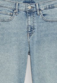 Lichtblauwe spijkerbroek met een vervaagde wassing, ontwerp met vijf zakken, riemlussen en een knoopsluiting. Zachte textuur met zichtbare stiksels.