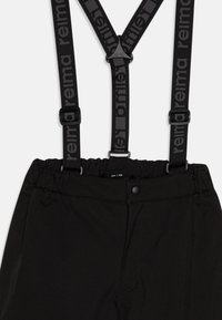 Pantaloni neri con bretelle nere regolabili, dotati di una vita testurizzata e chiusura a scatto. Etichetta della taglia 158 visibile.