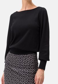 Schwarzer Strickpullover mit Boot-Ausschnitt und langen Ärmeln, mit gerafften Details an den Schultern und tailliertem Schnitt.