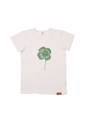 Weißes T-Shirt mit kurzen Ärmeln, das einen grünen vierblättrigen Kleeblatt-Druck mit einem roten Marienkäfer zeigt, sowie einem kleinen braunen Etikett in der unteren linken Ecke.