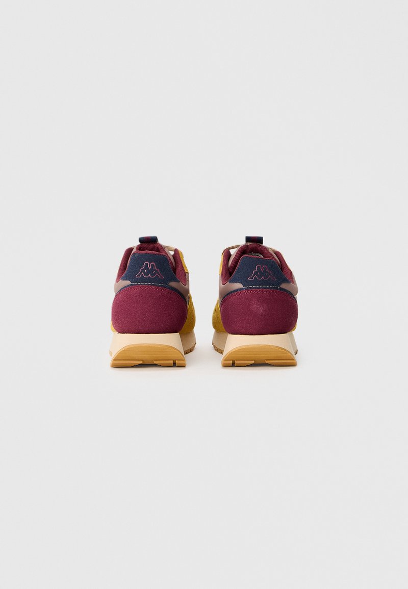 Vista posteriore di scarpe da ginnastica con un design color bordeaux e giallo, tessuto strutturato e suola in gomma con accenti marrone chiaro.
