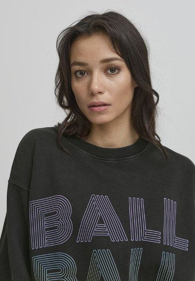 Svart hettegenser med flerfarget, stripet tekst som staver "BALL." Har rund halslinning og avslappet passform. Mykt, teksturert stoff.
