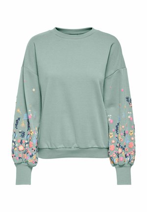Sweatshirt vert clair avec broderie florale sur les manches, à encolure ronde, avec des poignets côtelés et une coupe décontractée. Texture de tissu douce.