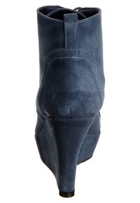 Stivaletto con tacco alto in suede blu navy con punta affusolata e tacco a cono, caratterizzato da una texture liscia e un design semplice.