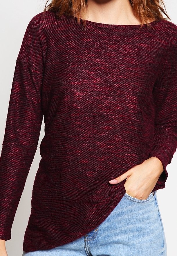 Bordeaux stickad topp med långa ärmar, rund halsringning och en något asymmetrisk nederkant, med en texturerad tyg med subtil lyster.