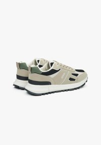 Beżowo-czarne sneakersy z teksturowaną cholewką z zamszu i siateczki, z białą podeszwą i zielonym akcentem na pięcie. Minimalistyczny design.