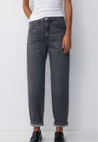 Grå denimjeans med avslappnad passform, med uppvikta fållar, femficksdesign och knappgylf. Slät textur, medelvikt.