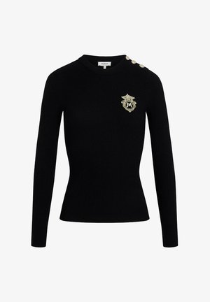 Suéter negro de manga larga con canalé, que presenta un escote redondo, un detalle de insignia dorada y tres botones decorativos en el hombro izquierdo.