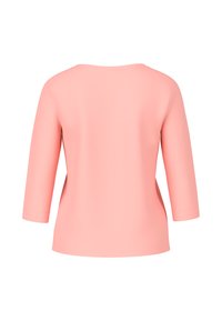 Pfirsichfarbene Bluse mit Dreiviertelärmeln, rundem Ausschnitt und glatter Textur. Verfügt über eine lockere Passform und minimale Nähdetails.
