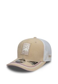 Beżowa czapka z teksturowanym wzorem, białymi siateczkowymi panelami i fioletowym akcentem na daszku. Posiada naszywkę z logo oraz regulowane zapięcie na zatrzask.