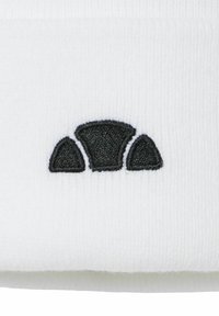 Beanie blanca con un logotipo negro texturizado y bordado, que presenta tres formas curvas dispuestas en fila en la parte delantera.