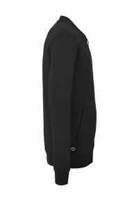 Sweatshirt noir en tissu doux avec une fermeture éclair sur le devant, des poches latérales et des poignets côtelés. Doté d'un logo près de l'ourlet.