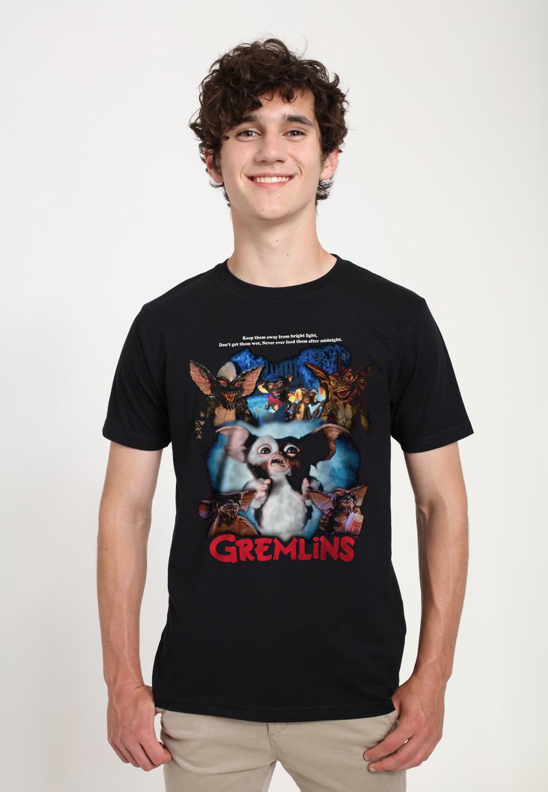 Černé tričko s barevným grafikou "Gremlins" zobrazující více postav a text, s kulatým výstřihem, krátkými rukávy a z bavlněné tkaniny.