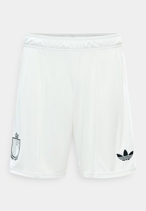 Valged spordipüksid elastse vöökohaga, millel on must Adidas logo paremal jalal ja vapp vasakul jalal.