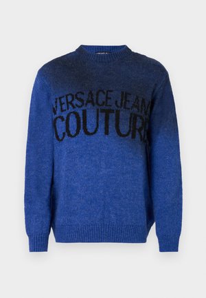 Sinine kudumine sviiter, millel on ümmargune kaelus ja soonikkoes mansetid. Esiküljel on must tekst "VERSACE JEANS COUTURE".