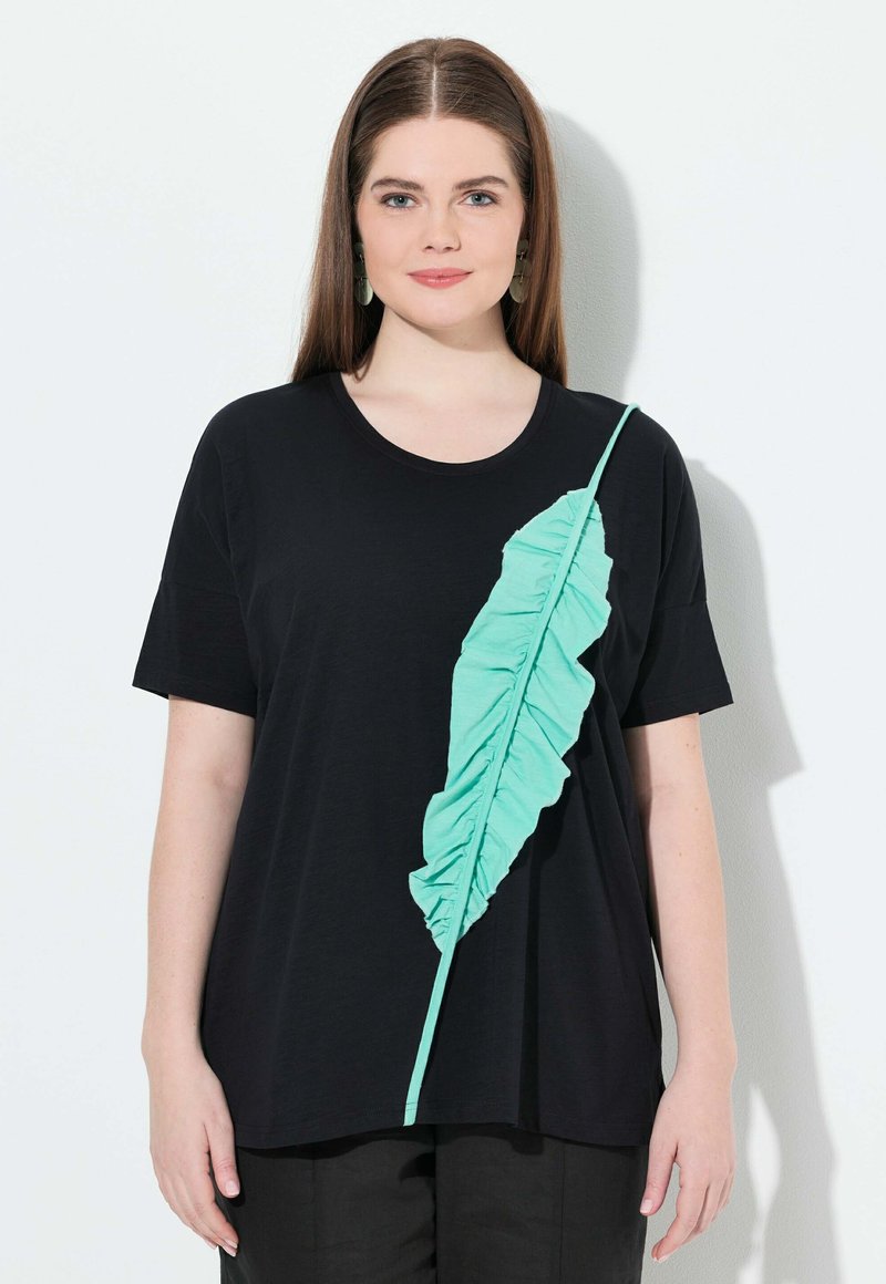 Camiseta negra de manga corta con un diseño de hojas turquesa con volantes en el frente, cuello redondo y corte relajado.