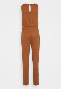 Macacão castanho sem mangas com costas em forma de buraco, faixa elástica na cintura e design de perna reta, feito de um tecido macio e texturizado.