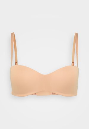 Nude push-up bh met gepolsterde cups, verstelbare bandjes en een glad, naadloos ontwerp. Beschikt over een haak-en-oogsluiting aan de achterkant.