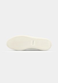 Semelle en caoutchouc blanche avec une surface texturée, forme légèrement courbée et un logo de marque embossé au centre. Convient pour des chaussures décontractées.
