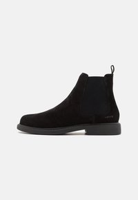 Svarta mocka Chelsea-boots med ribbad elastisk sidopanel och en dragflik. Har en platt gummisula och subtil logotypdetalj.
