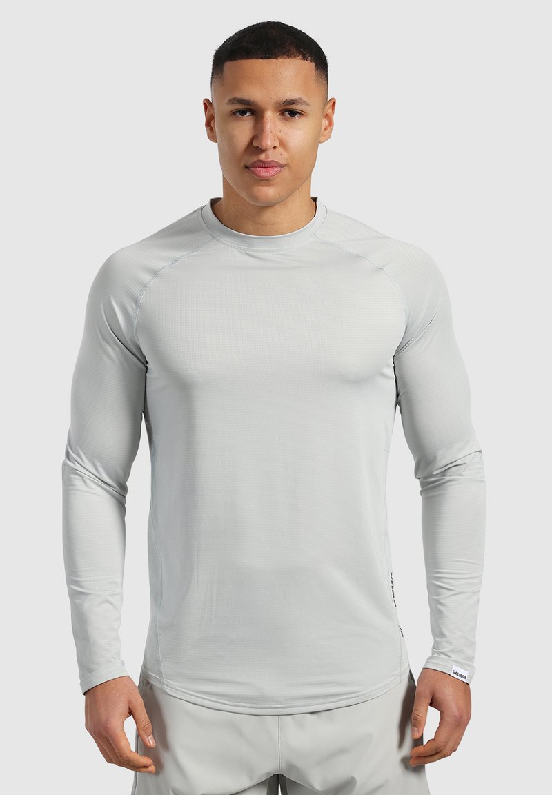 Helles graues langärmliges Sportshirt mit Rundhalsausschnitt, strukturiertem Stoff und dezenten Nähdetails. Der enganliegende Schnitt fördert die Beweglichkeit.