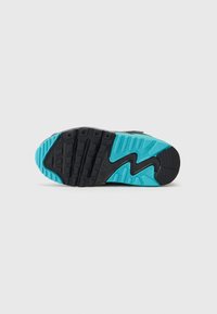 Súčasť tenisky Nike s čiernym základom a tyrkysovým akcentom, s textúrovaným gripovým vzorom. Výrazný cik-cak dizajn na podrážke.