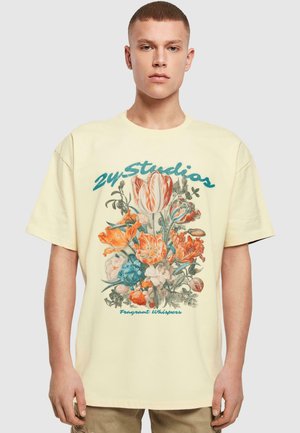 Short-sleeve, yellow cotton t-shirt featuring a floral graphic in vibrant orange and blue with "24 Studios" text and "Fragrant Whispers" below.