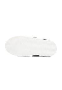 Witte sneakerzool met een rubberen textuur, voorzien van groeven voor grip en een afgeronde neus. Minimalistisch ontwerp zonder zichtbare branding.