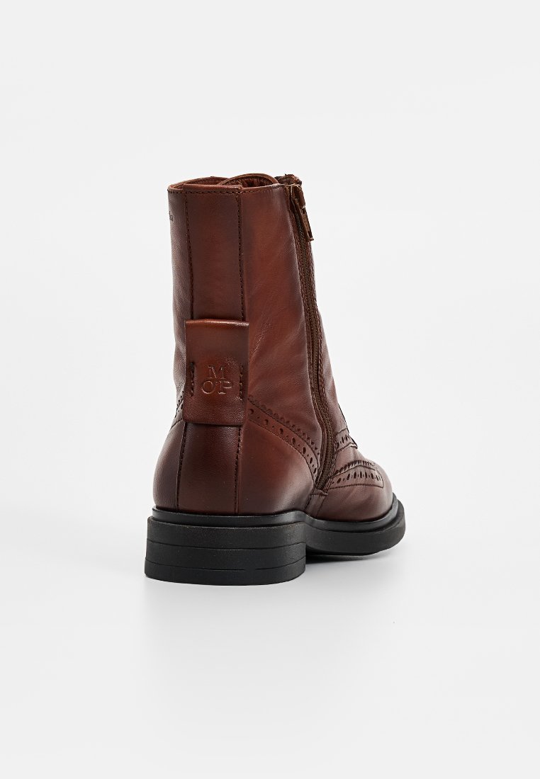 Braune Leder-Ankle-Boots mit strukturiertem Finish, seitlichem Reißverschluss, Broguemuster und einer schwarzen Gummisohle für zusätzlichen Grip.