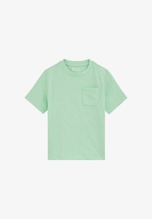 Camiseta de manga corta y cuello redondo de color verde claro con un pequeño bolsillo en el pecho, en el lado izquierdo, mostrada extendida sobre un fondo blanco.