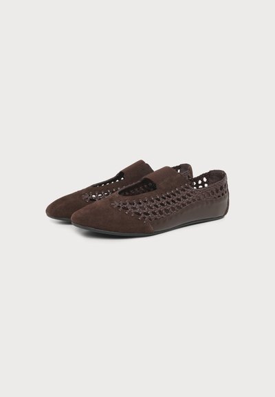 Ζευγάρι καφέ πλεκτά γυναικεία παπούτσια slip-on με υφές σουέτ και δέρματος, στρογγυλεμένες μύτες και χαμηλές μαύρες σόλες.